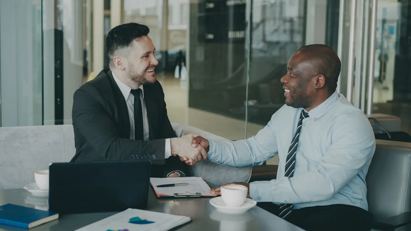 Poignée de main entre deux partenaires professionnels lors d'une réunion